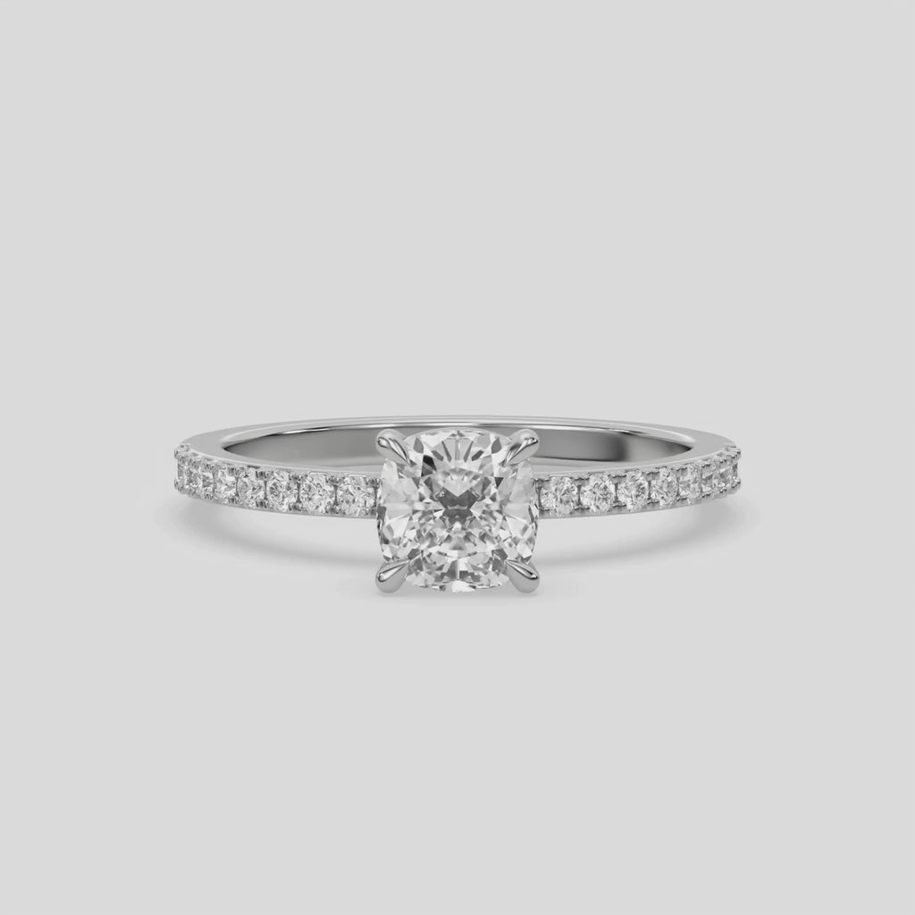 This ring is made with a cushion diamond set in four-prong setting, and is complemented by a round pave diamonds band.