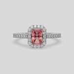 This video features a white gold Radiant Diamond Halo Engagement Ring is made with a fancy pink radiant solitaire diamond set in a four-prong setting