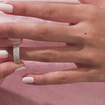 Elegant multi-row pave set princess and round diamond wedding band in 14k yellow gold , worn on a finger. A beautiful statement jewelry piece shown close up.