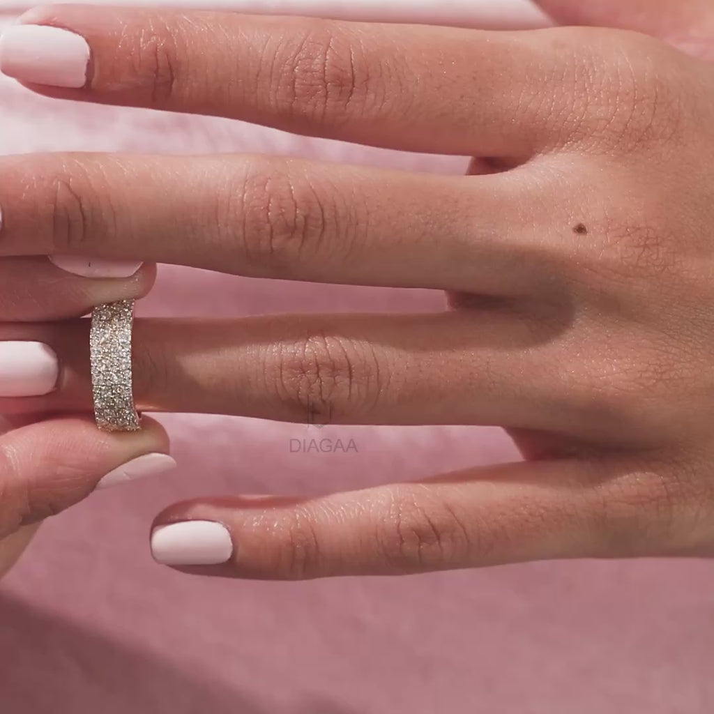 Elegant multi-row pave set princess and round diamond wedding band in 14k yellow gold , worn on a finger. A beautiful statement jewelry piece shown close up.