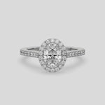 This video features a white gold Oval Diamond Halo Engagement Ring is made with an oval solitaire diamond set in a four-prong setting, surrounded by a halo of round diamonds all set on a pave band 