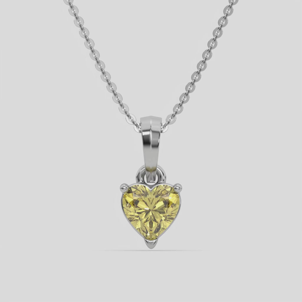 This white gold Fancy Yellow Heart Solitaire Diamond Necklace made with a fancy yellow heart cut diamond in a four prong setting with adjustable chain