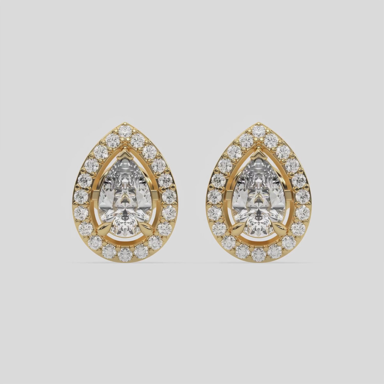 This video features a yellow gold Classic Pear Diamond Halo Earrings made with a pear-cut solitaire diamonds set in a four prong setting 