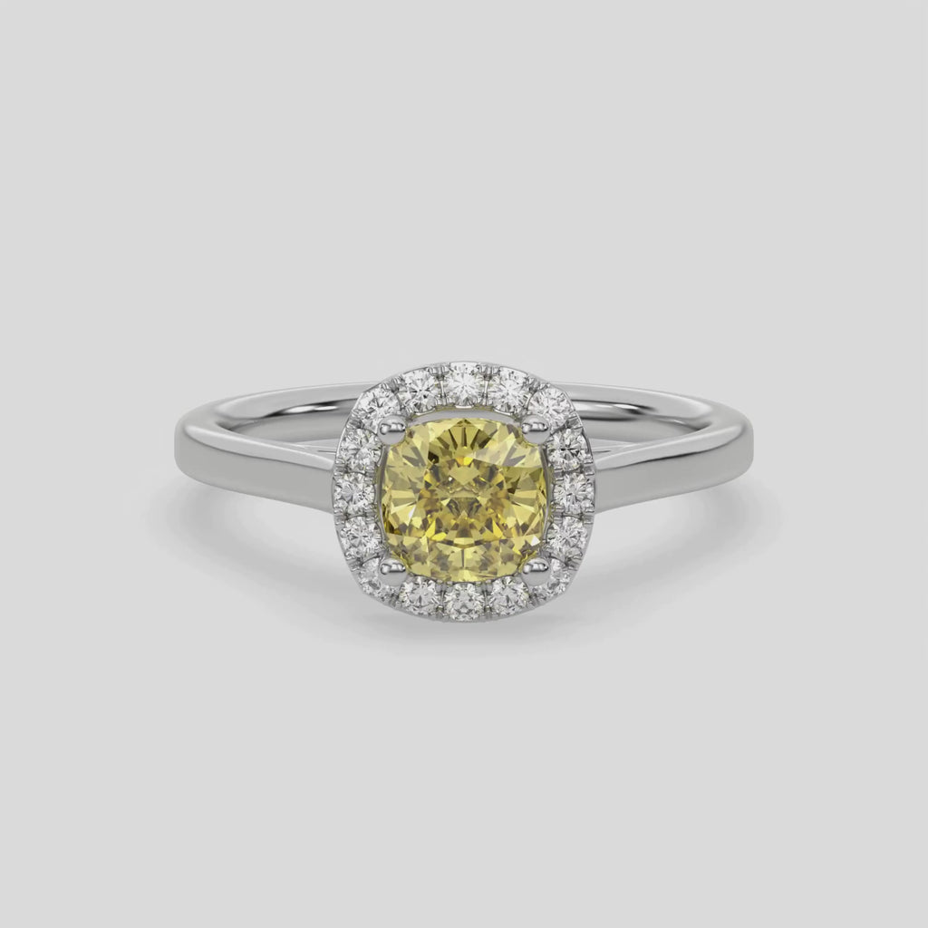 This video features a white gold ring features a fancy Yellow cushion solitaire diamond set in a four-prong setting