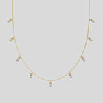 Oval Dangling Diamond Necklace made with nine oval cut diamonds each set in a prong setting, distributed evenly along the chain