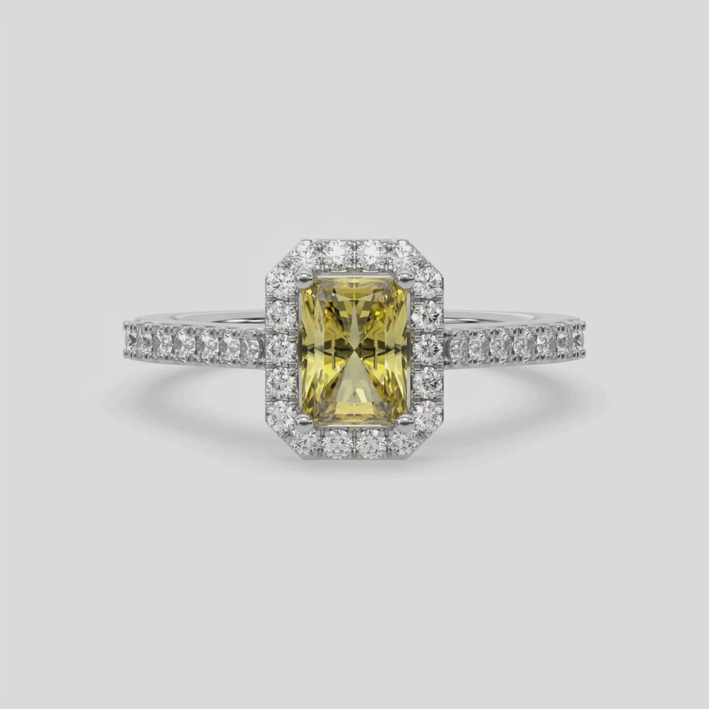 This video features a white gold Radiant Diamond Halo Engagement Ring is made with a fancy yellow radiant solitaire diamond set in a four-prong setting