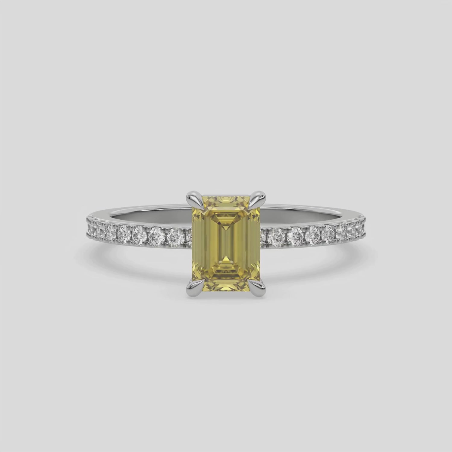 This video features a white gold ring is made with an fancy Yellow emerald solitaire diamond set in four-prong setting, and is complemented by a round pave diamonds band