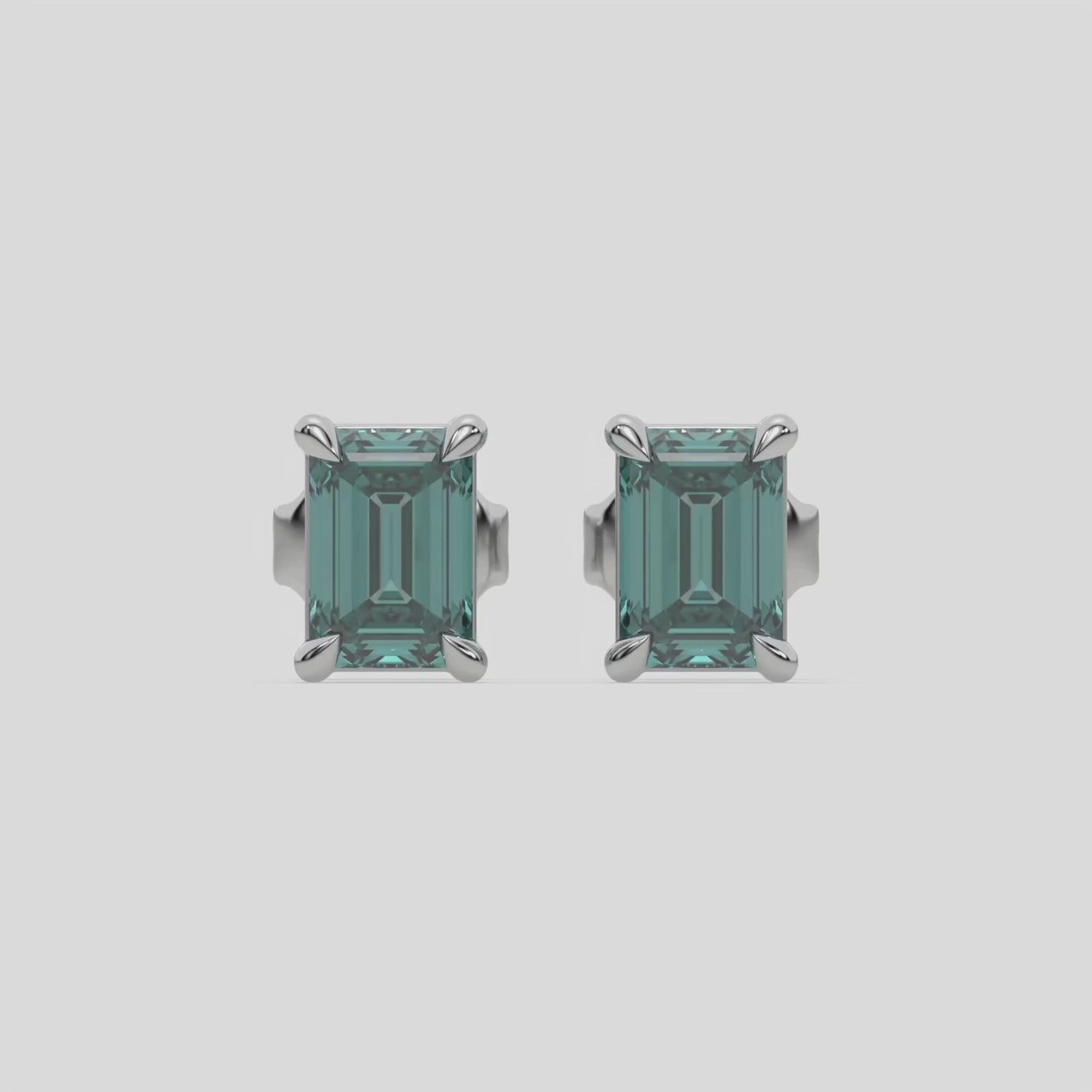 This video features a white gold Classic Emerald Diamond Earrings made with an fancy green emerald-cut diamonds set in a four prong setting