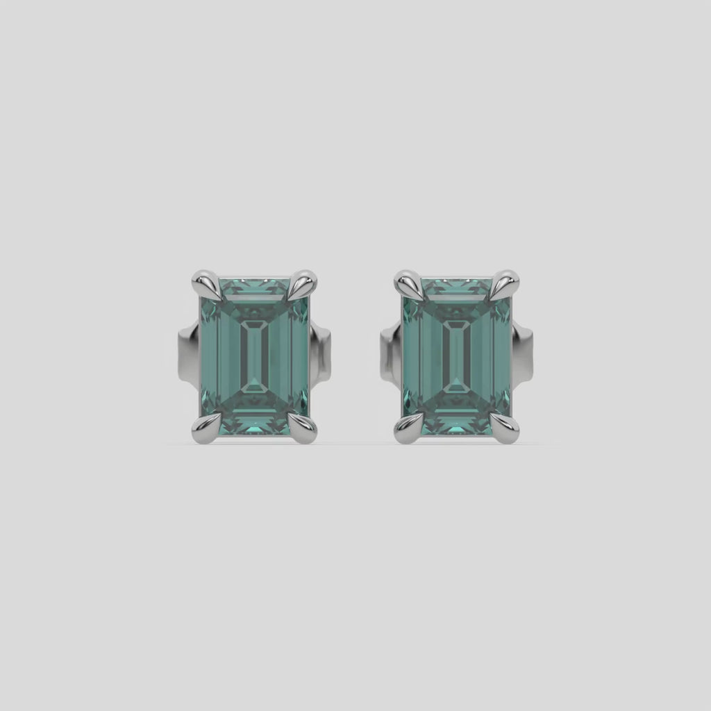 This video features a white gold Classic Emerald Diamond Earrings made with an fancy green emerald-cut diamonds set in a four prong setting