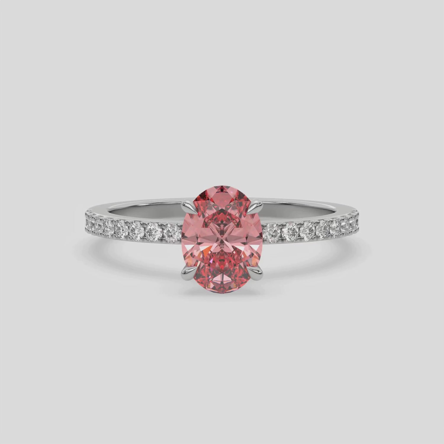 This video features a white gold ring is made with an fancy Pink oval solitaire diamond set in four-prong setting, and is complemented by a round pave diamonds band