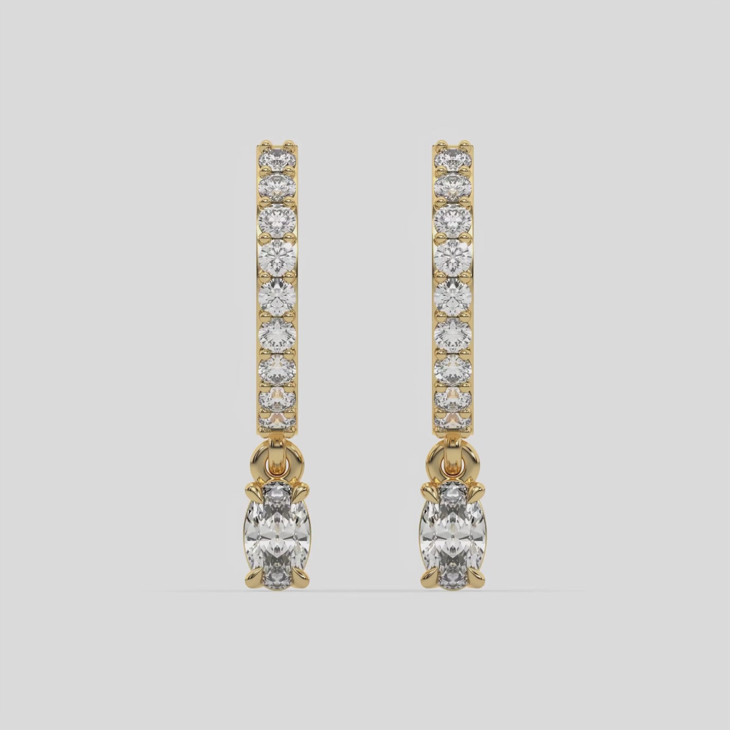 This video features a yellow gold Dangling Oval Diamond Hoop Earrings handmade with round brilliant-cut diamonds in prong setting and an oval solitaire hanging at the bottom