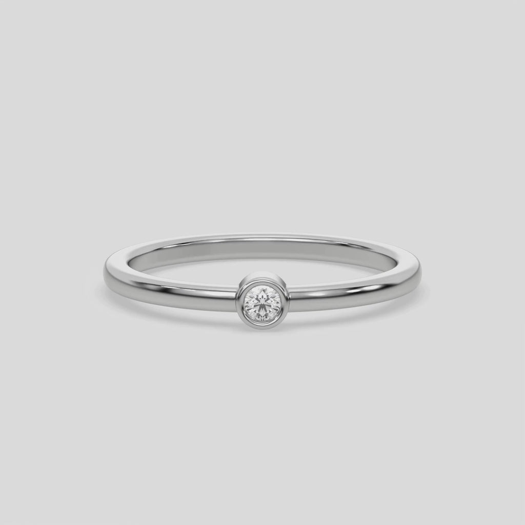 This video features a Thin white gold band with a round solitaire diamond in bezel setting