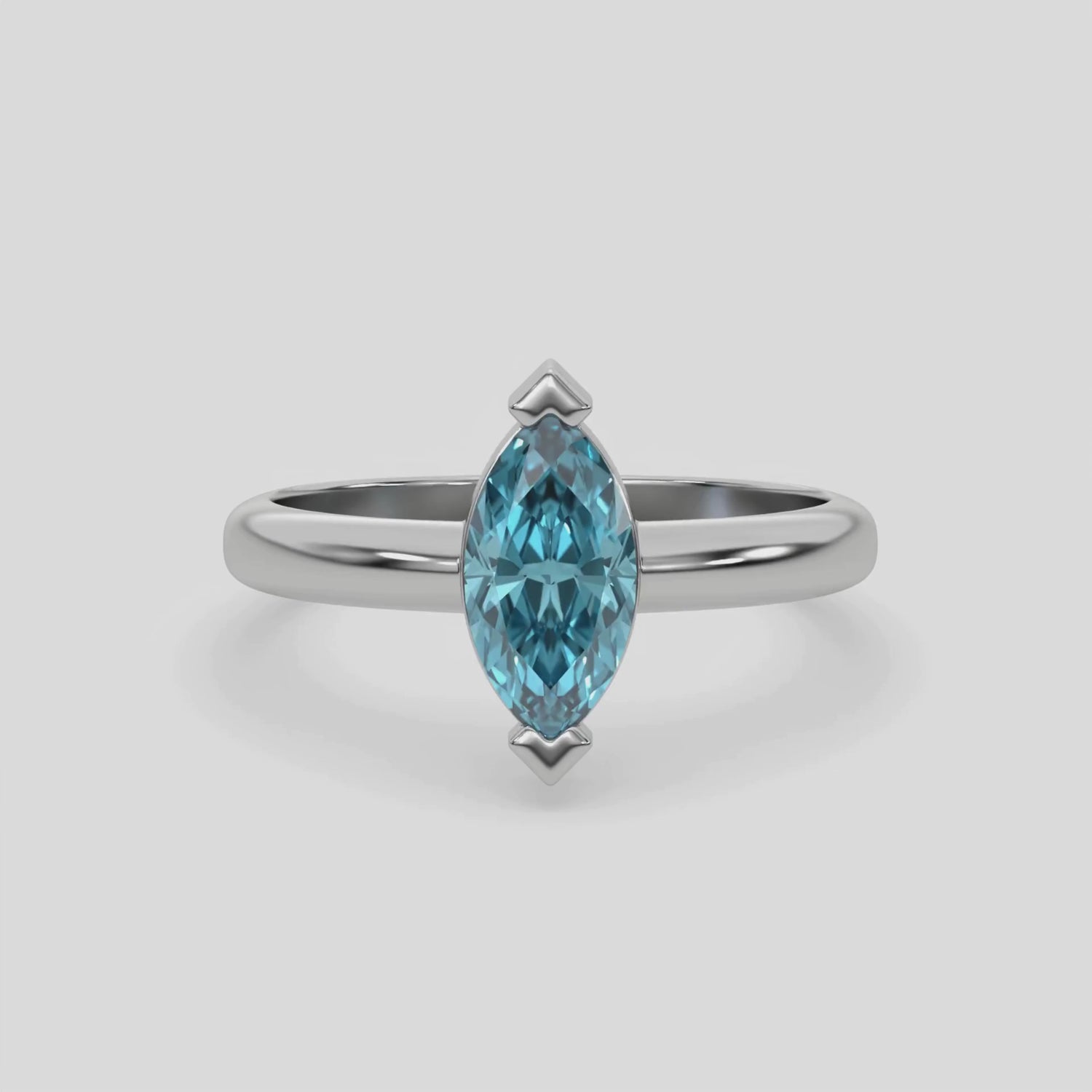 This video features a white gold ring features a fancy Blue marquise solitaire diamond elegantly secured in a two v-prong setting on a solid gold band 