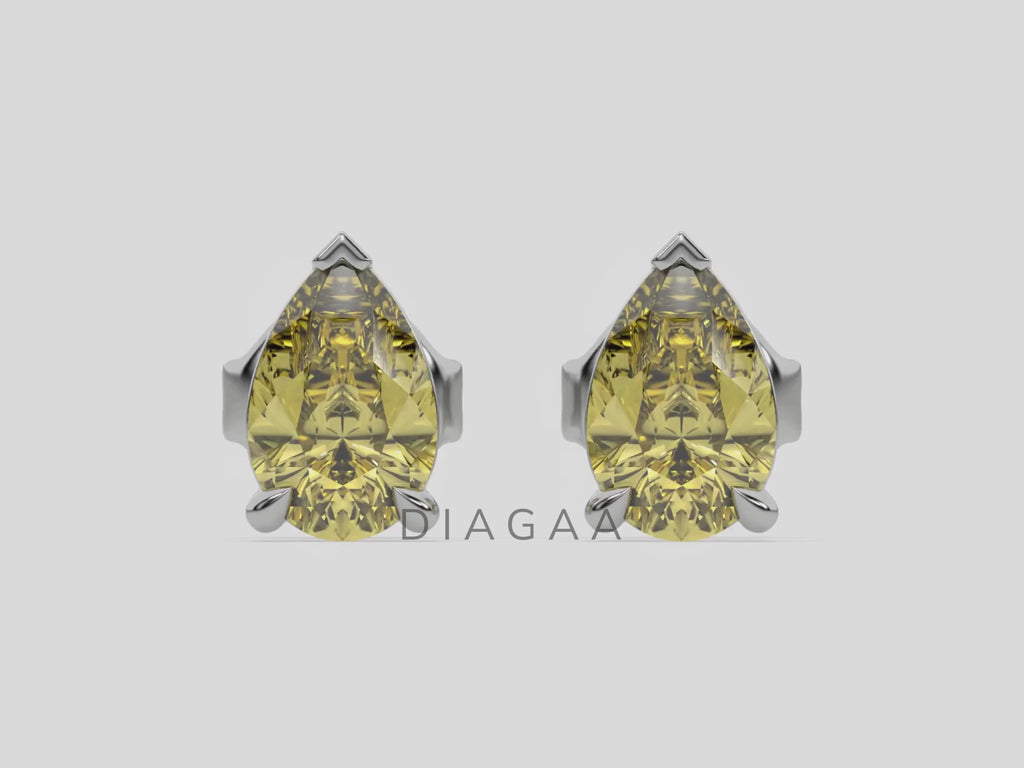 18k white gold Pear shaped diamond Earrings made with a fancy yellow pear shaped diamond set in a four prong setting