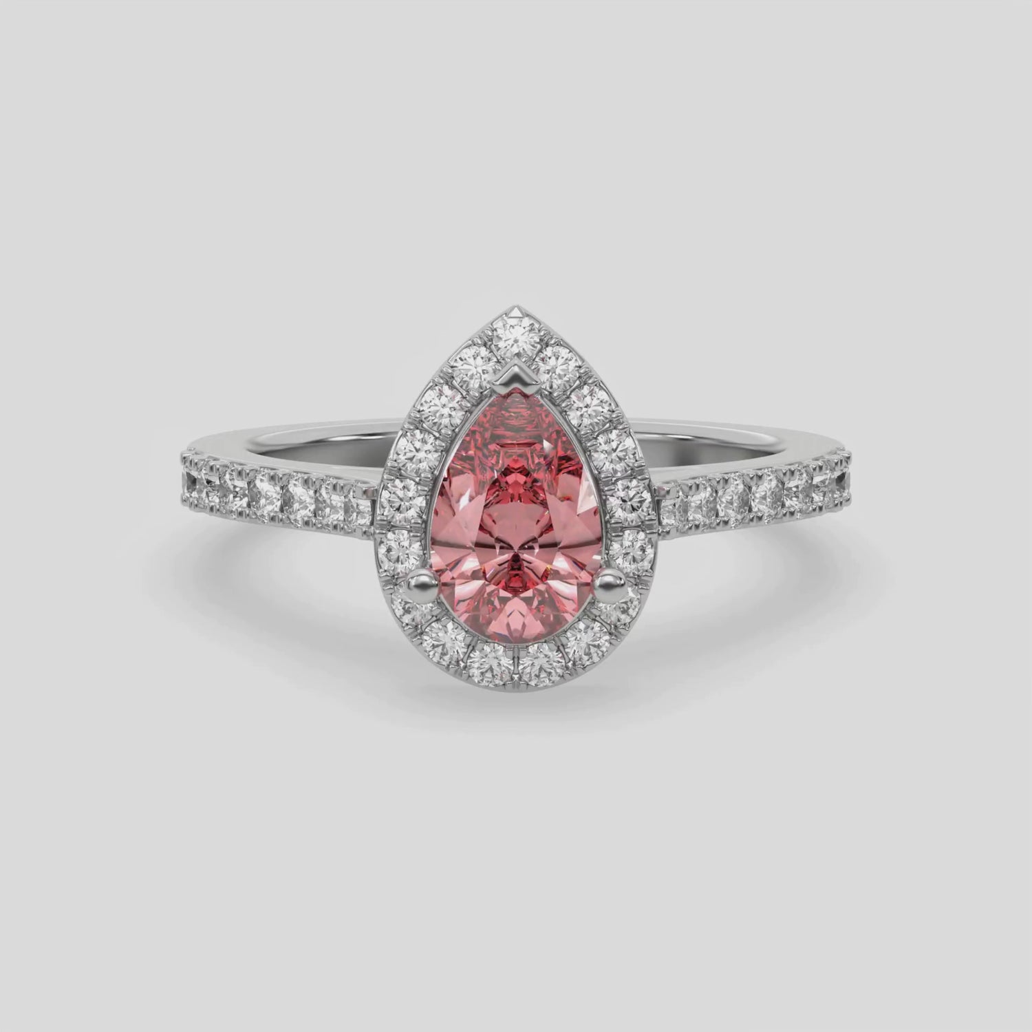 This video features a white gold Pear Diamond Halo Engagement Ring is made with a fancy pink pear solitaire diamond set in a four-prong setting