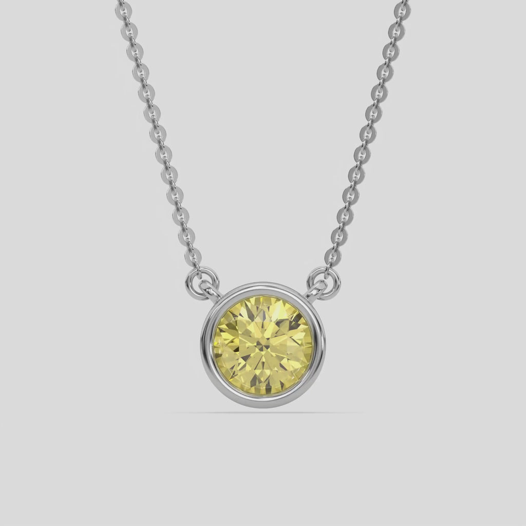 This white gold Fancy Yellow Round Solitaire Diamond Necklace made with a fancy yellow round brilliant-cut diamond in bezel setting with adjustable chain