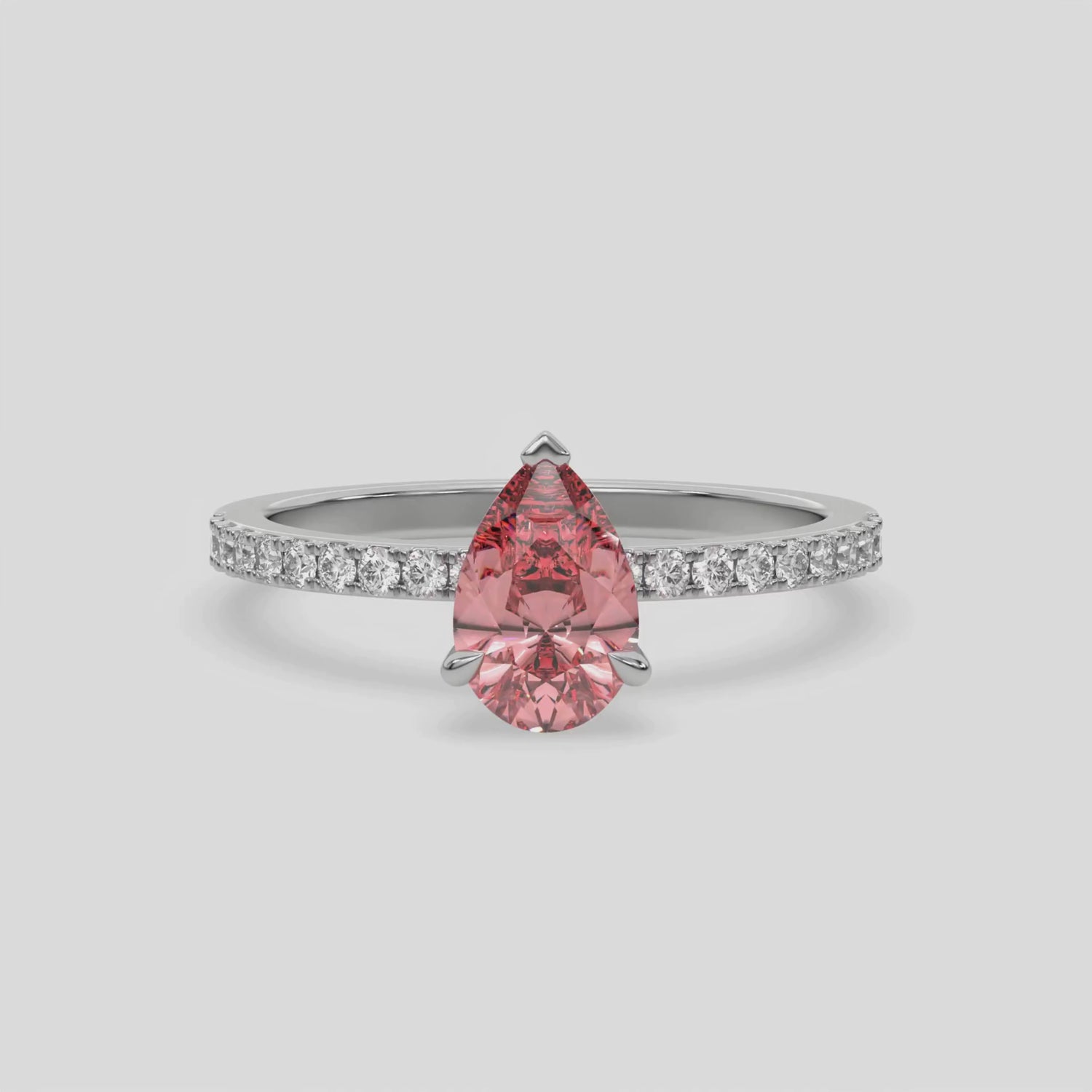 This video features a white gold ring is made with a fancy Pink pear solitaire diamond set in three-prong setting, and is complemented by a round pave diamonds band