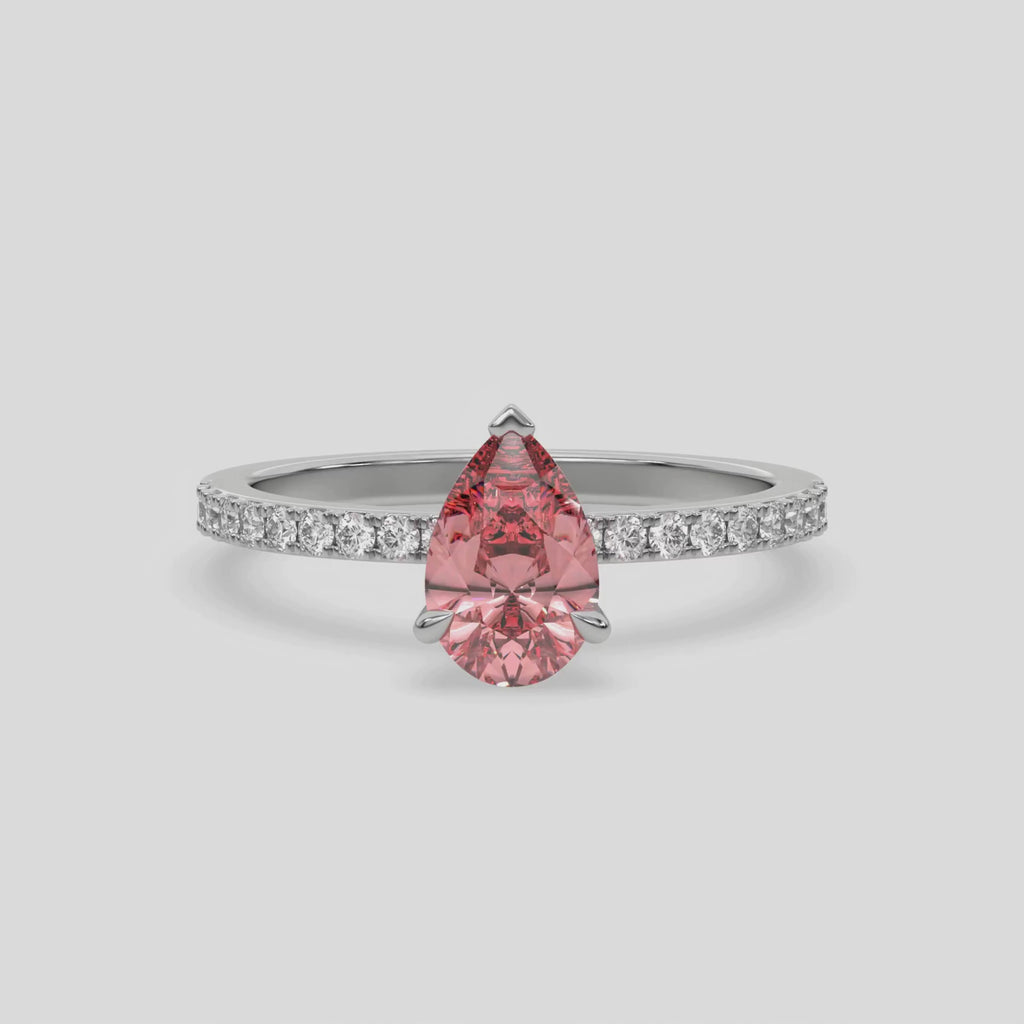 This video features a white gold ring is made with a fancy Pink pear solitaire diamond set in three-prong setting, and is complemented by a round pave diamonds band