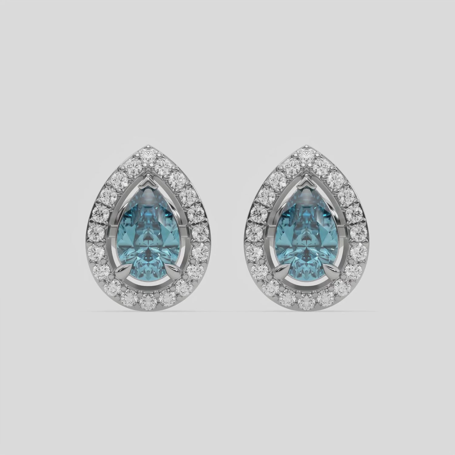 This video features a white gold Classic Pear Diamond Halo Earrings made with a fancy Blue pear cut solitaire diamonds set in a four prong setting