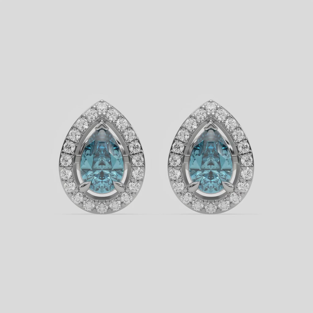 This video features a white gold Classic Pear Diamond Halo Earrings made with a fancy Blue pear cut solitaire diamonds set in a four prong setting