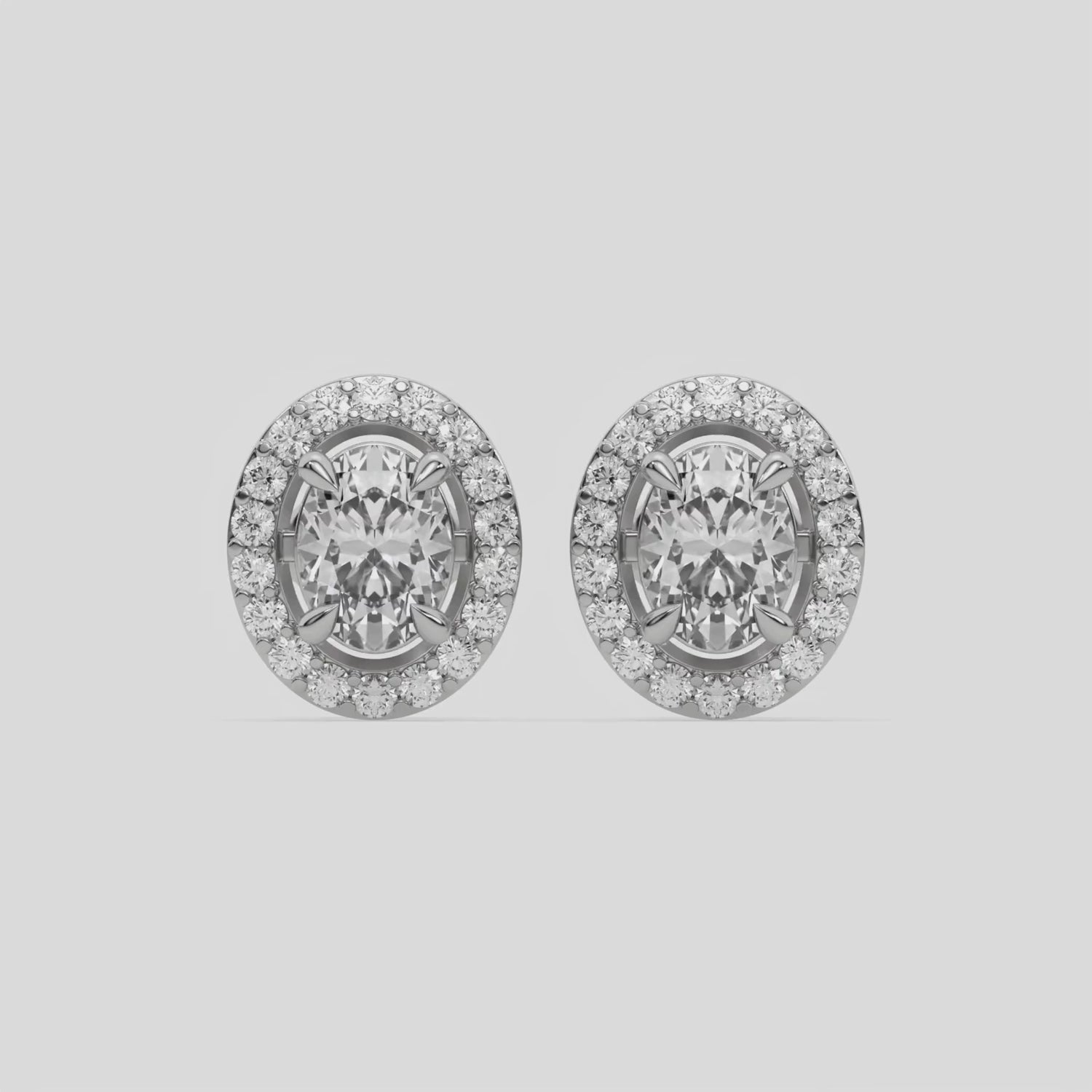 This video features a white gold Classic Oval Diamond Halo Earrings made with an oval-cut solitaire diamonds set in a four prong setting