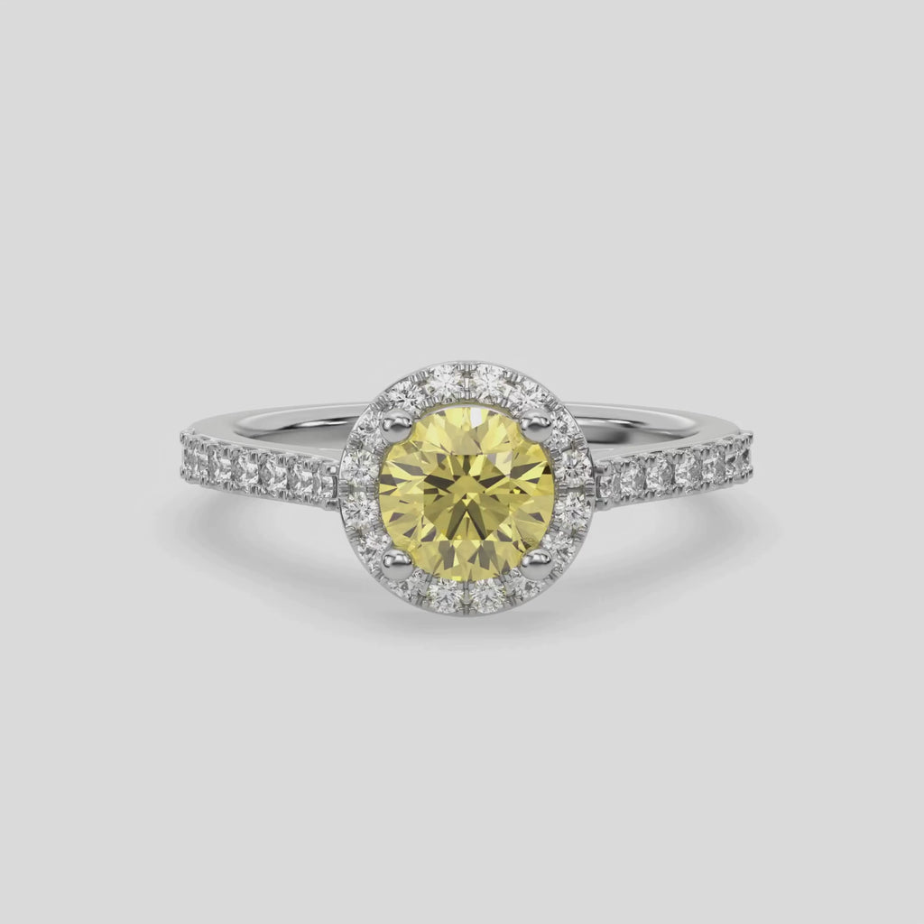 This video features a white gold Round Diamond Halo Engagement Ring is made with a fancy Yellow round solitaire diamond set in a four-prong setting