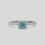 This video features a white gold ring is made with a fancy Blue cushion solitaire diamond set in four-prong setting