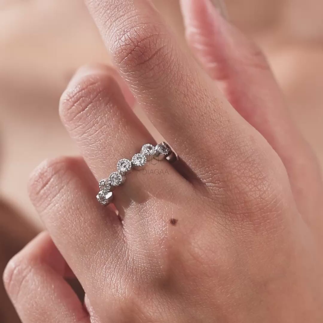White gold zig-zag band ring worn on a hand, featuring staggered round diamonds in vintage milgrain bezel settings wedding band.
