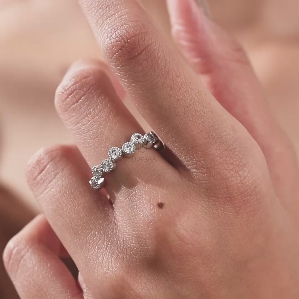 White gold zig-zag band ring worn on a hand, featuring staggered round diamonds in vintage milgrain bezel settings wedding band.
