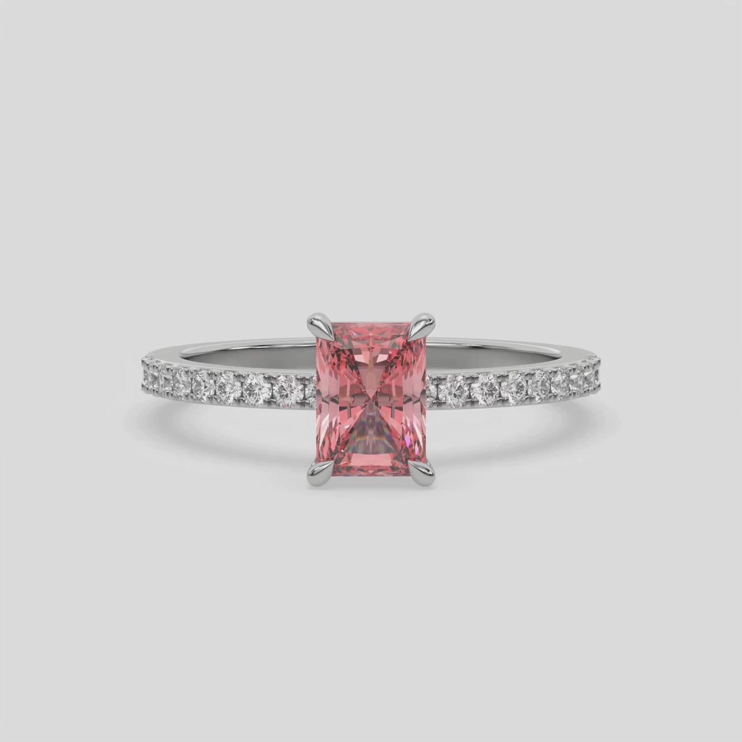 This video features a white gold ring is made with a fancy Pink radiant solitaire diamond set in four-prong setting, and is complemented by a round pave diamonds band