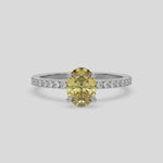 This video features a white gold ring is made with an fancy Yellow oval solitaire diamond set in four-prong setting, and is complemented by a round pave diamonds band