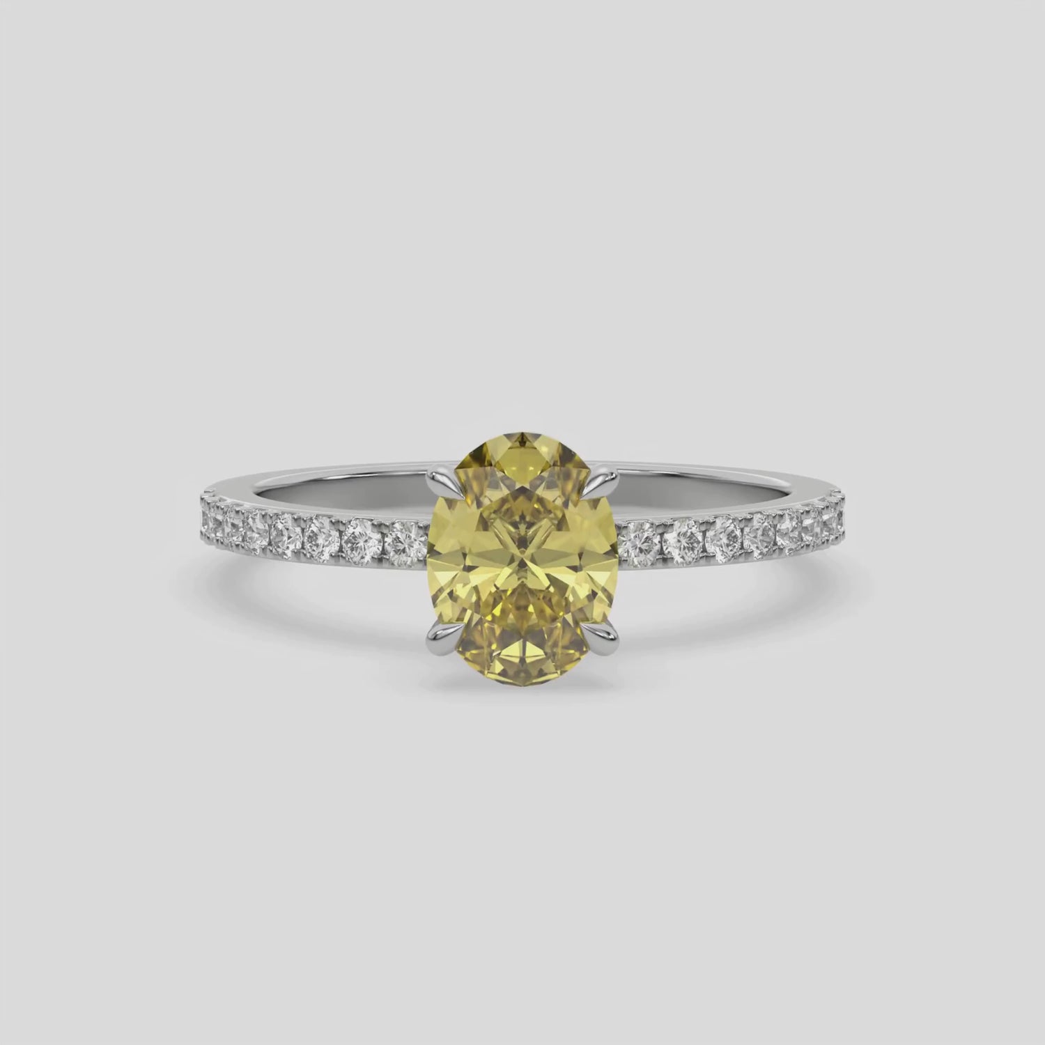 This video features a white gold ring is made with an fancy Yellow oval solitaire diamond set in four-prong setting, and is complemented by a round pave diamonds band