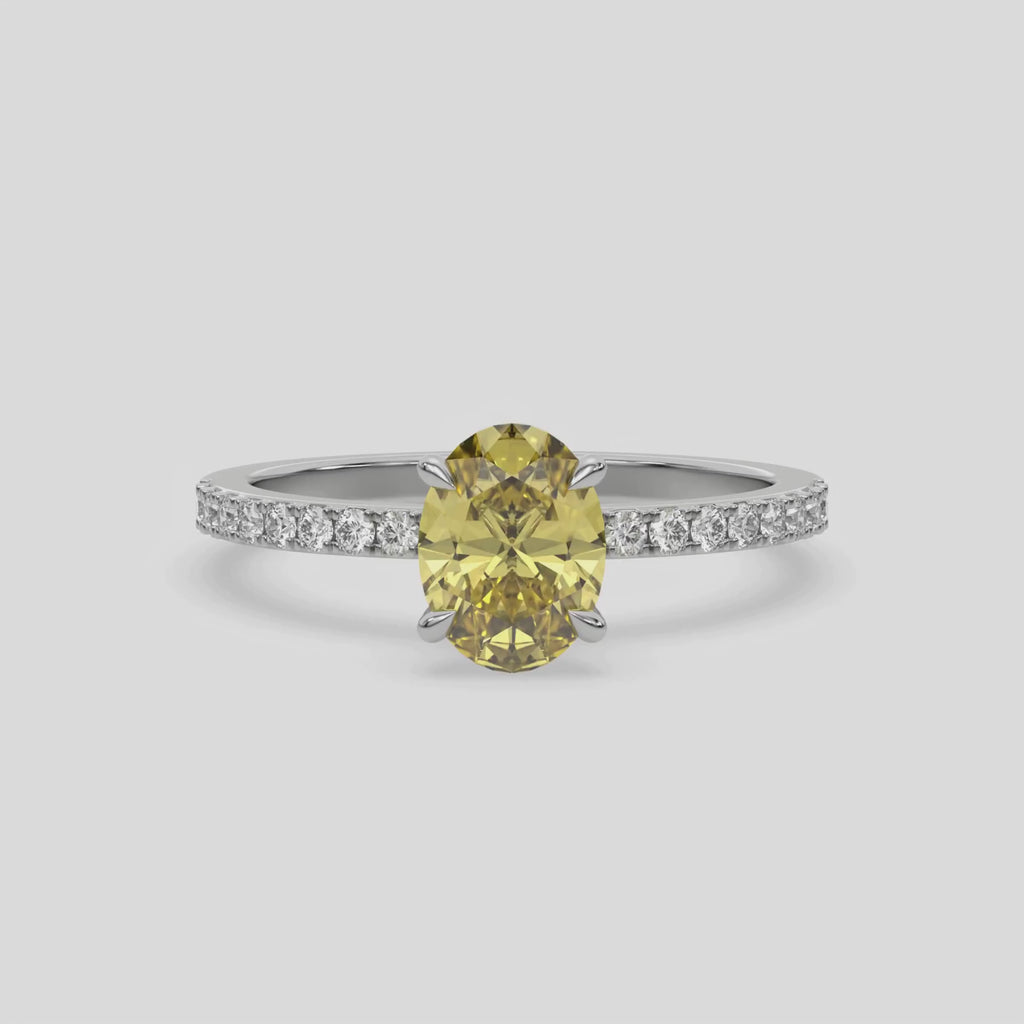 This video features a white gold ring is made with an fancy Yellow oval solitaire diamond set in four-prong setting, and is complemented by a round pave diamonds band