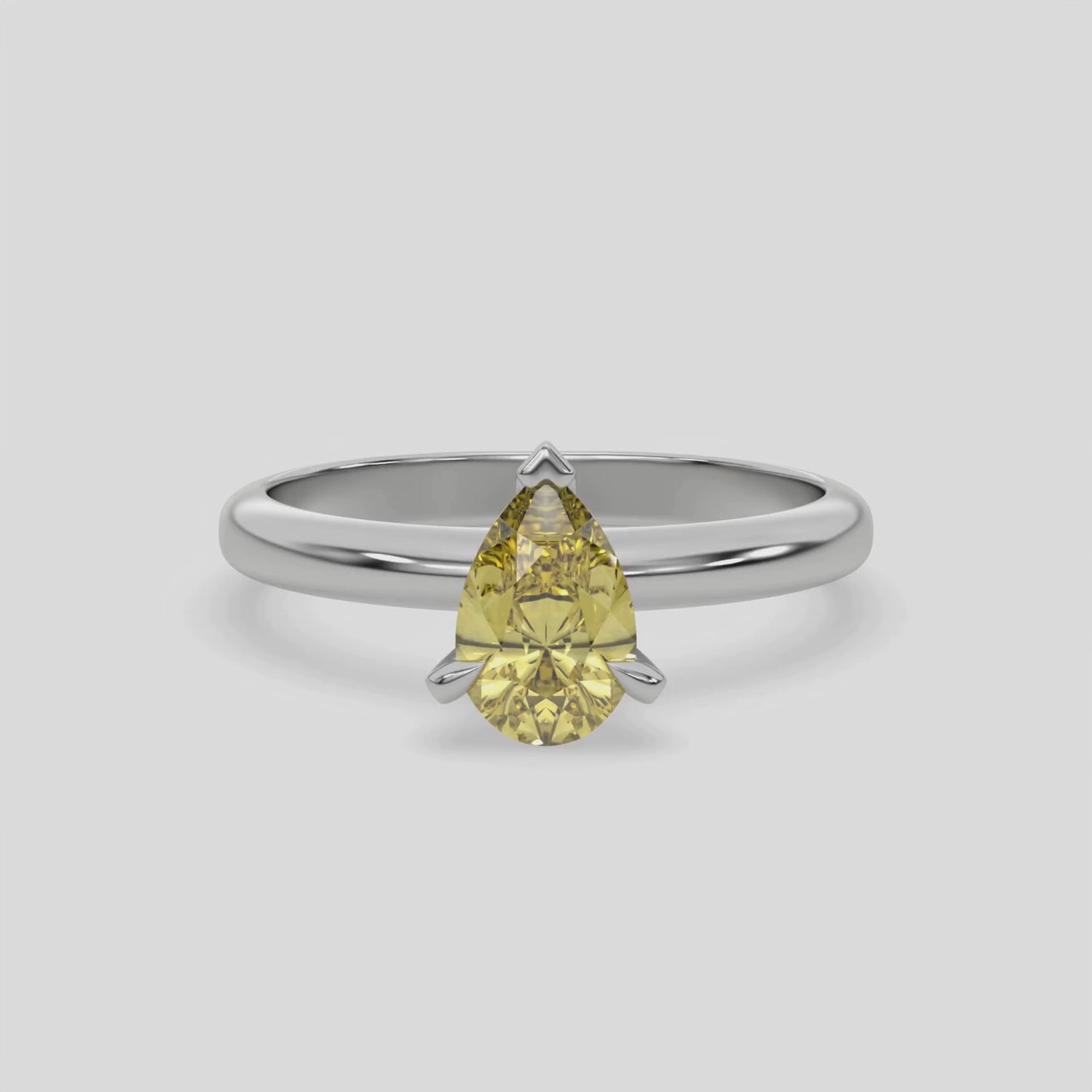 This video features a white gold ring features a fancy Yellow pear solitaire diamond elegantly secured in a three-prong setting on a solid gold band