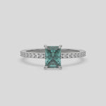 This video features a white gold ring is made with a fancy Green radiant solitaire diamond set in four-prong setting, and is complemented by a round pave diamonds band