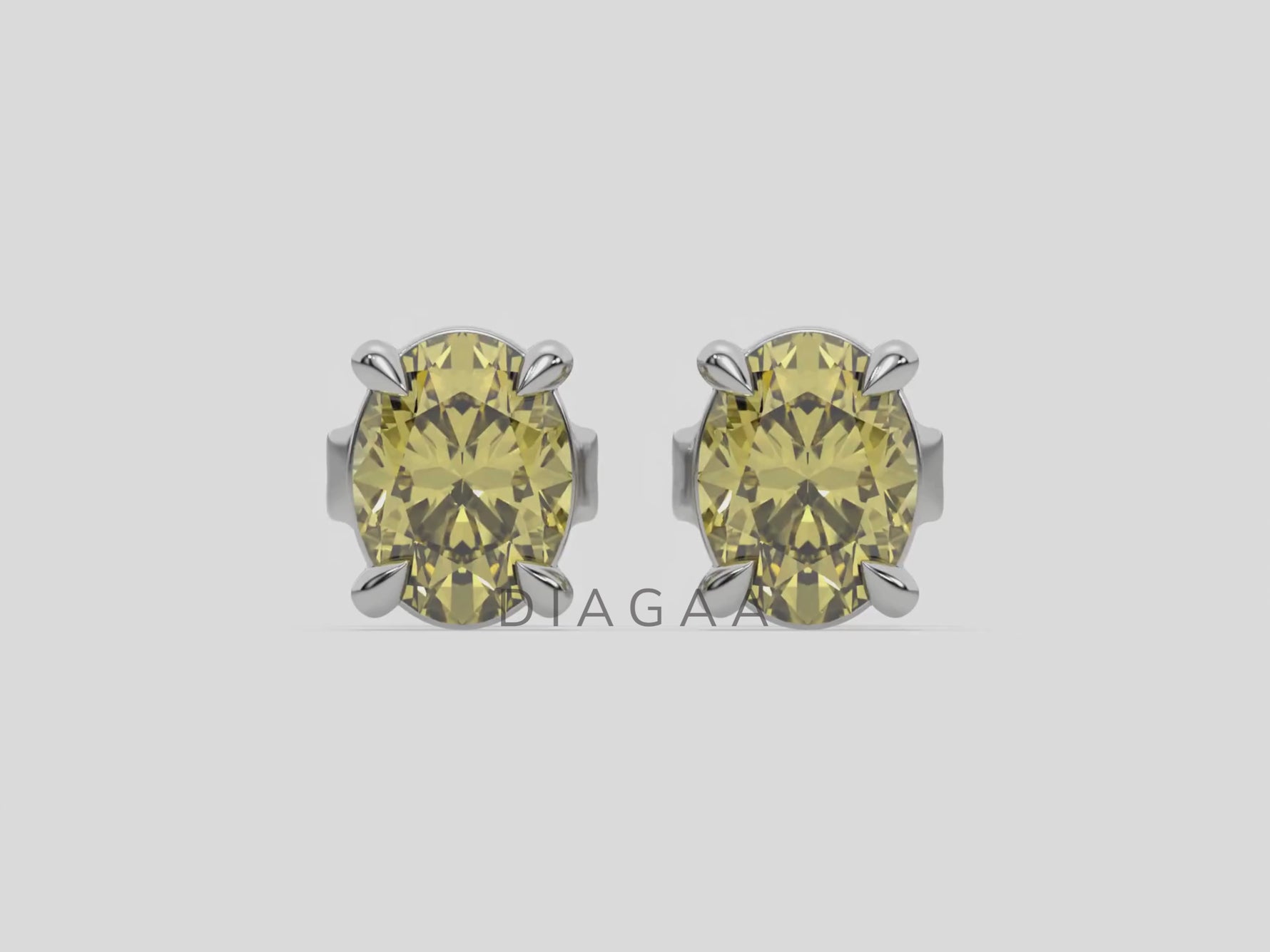18k white gold oval diamond stud Earrings made with an fancy yellow oval cut diamond set in a four prong setting