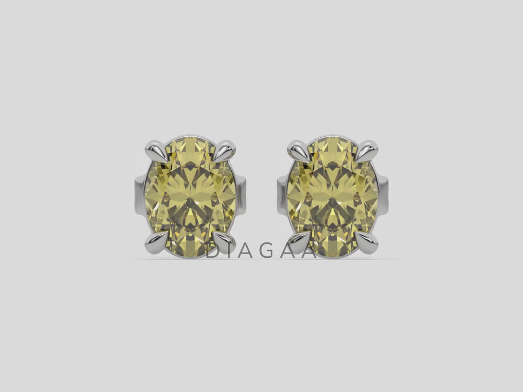 18k white gold oval diamond stud Earrings made with an fancy yellow oval cut diamond set in a four prong setting