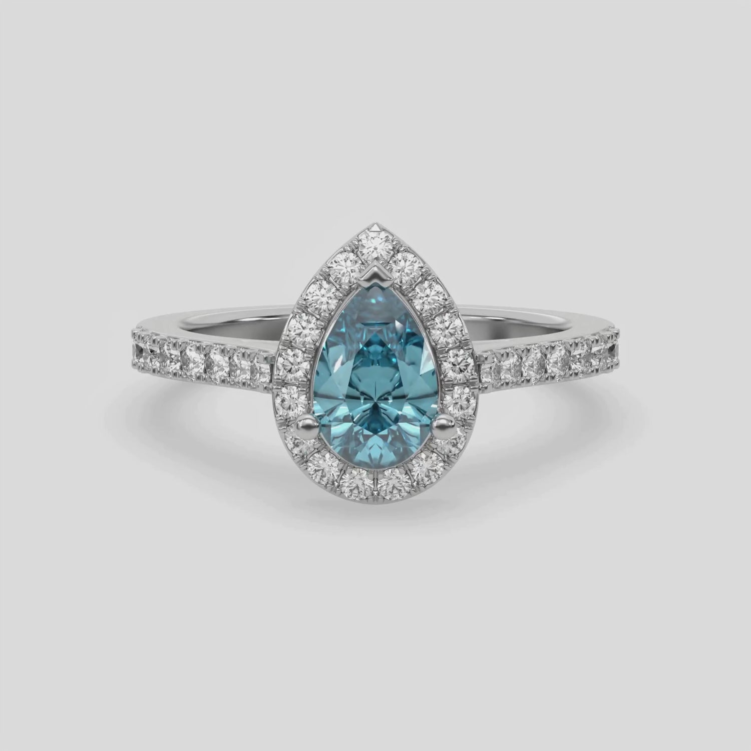 This video features a white gold Pear Diamond Halo Engagement Ring is made with a fancy blue pear solitaire diamond set in a four-prong setting