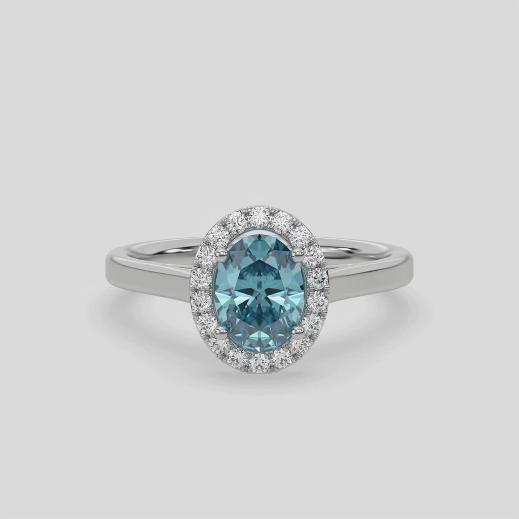 This video features a white gold ring is made with an fancy Blue oval solitaire diamond set in a four-prong setting