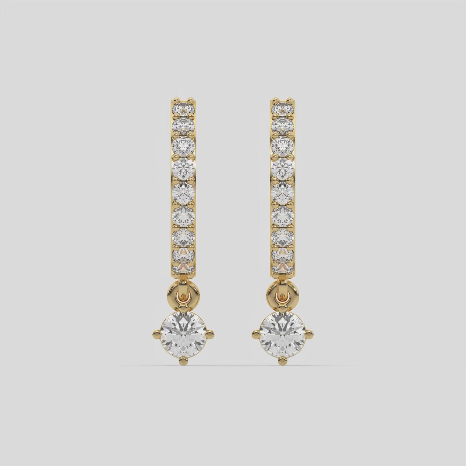 This video features a yellow gold Dangling Round Diamond Hoop Earrings handmade with round brilliant-cut diamonds in prong setting and a round solitaire hanging at the bottom