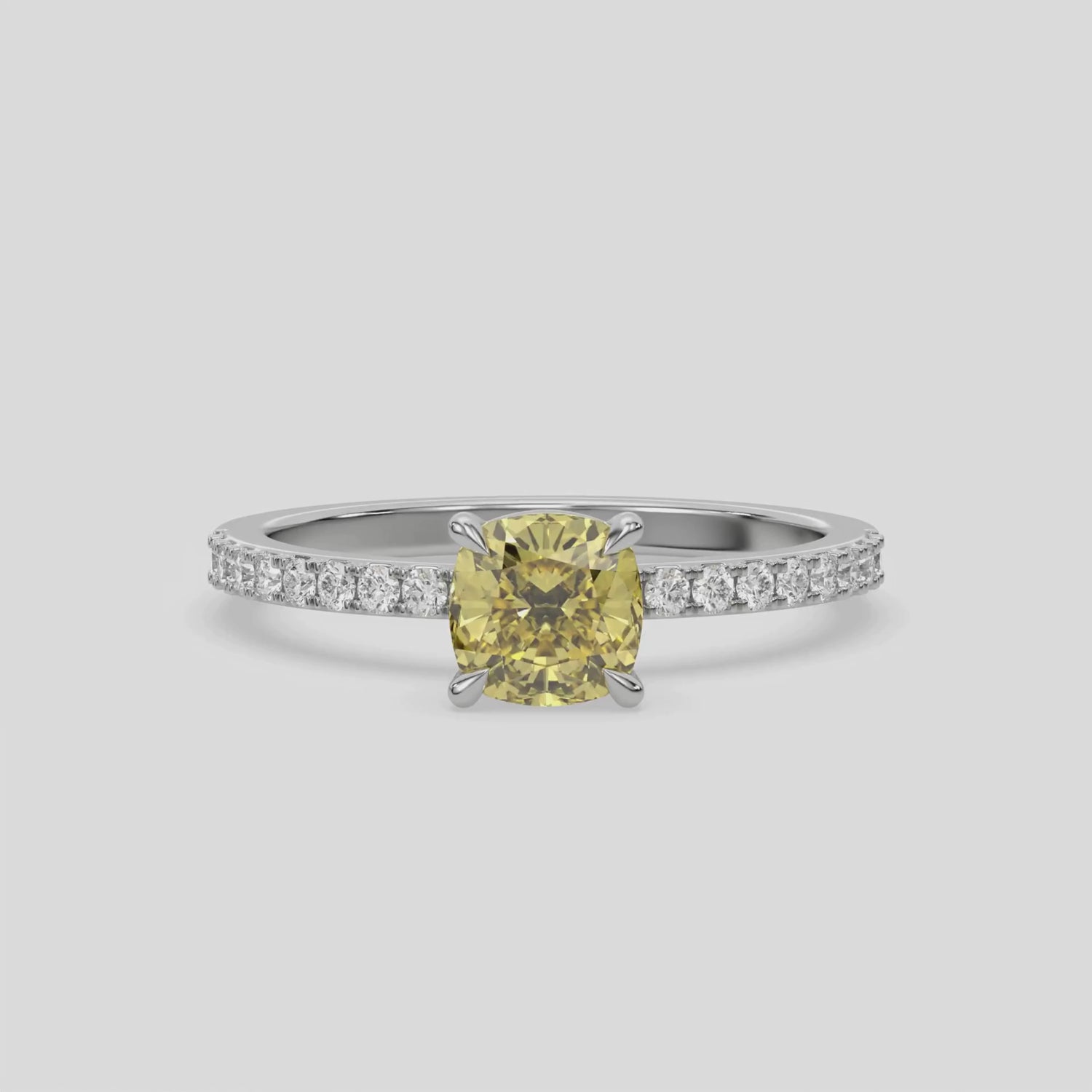 This video features a white gold ring is made with a fancy Yellow cushion solitaire diamond set in four-prong setting