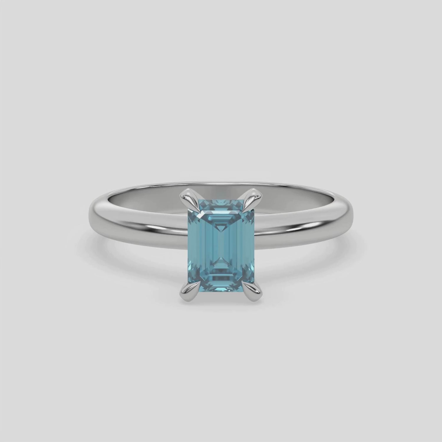 This video features a white gold ring features an fancy Blue emerald solitaire diamond elegantly secured in a four-prong setting on a solid gold band 