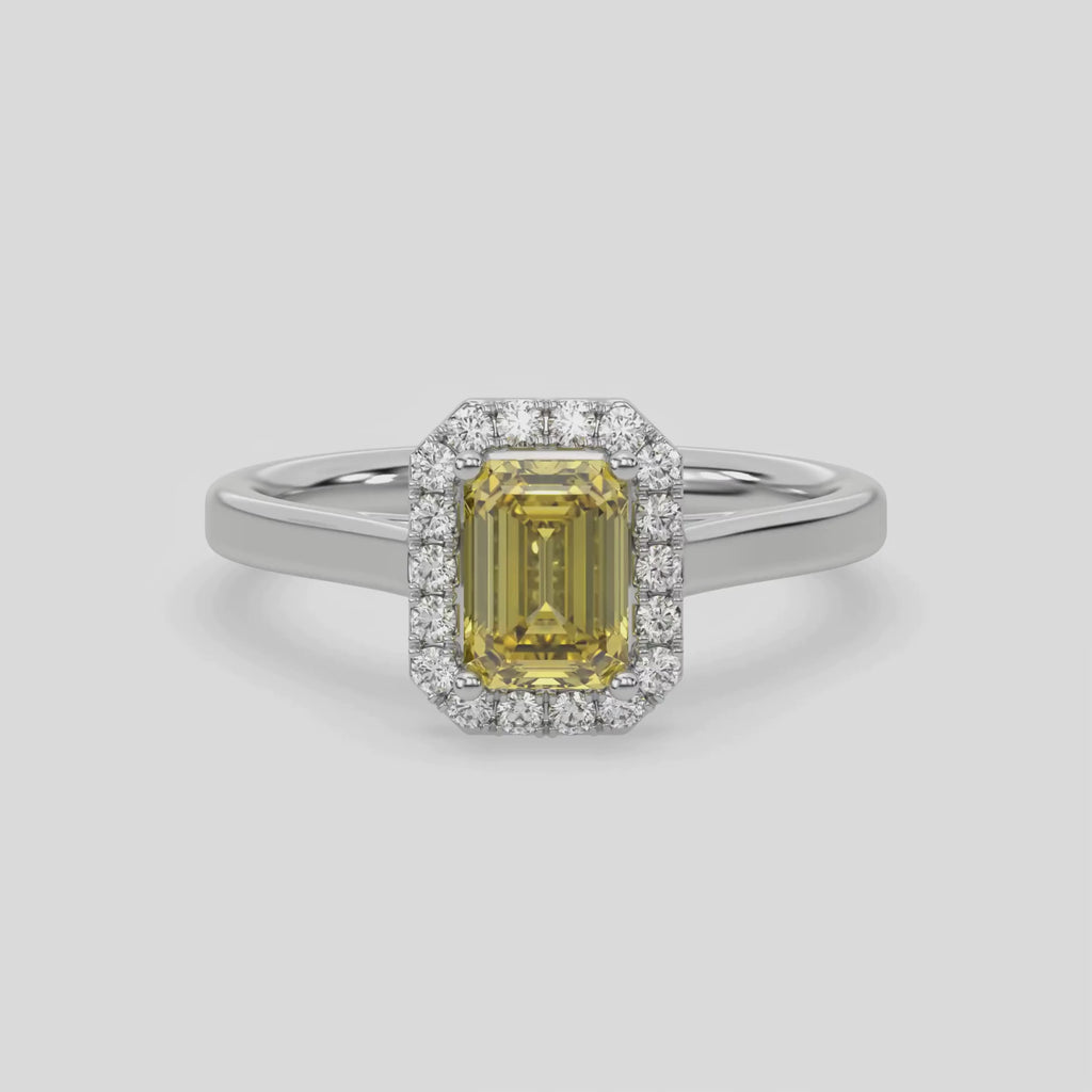 This video features a white gold ring is made with an fancy Yellow emerald solitaire diamond set in a four-prong setting