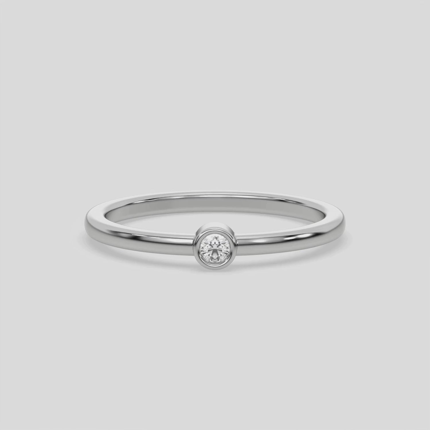 This video features a Thin white gold band with a round solitaire diamond in bezel setting