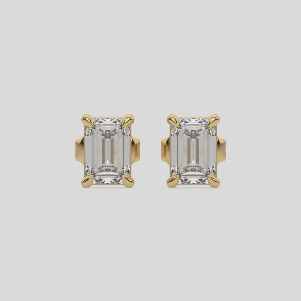 This video features a yellow gold Classic Emerald Diamond Earrings made with an emerald-cut diamonds set in a four prong setting