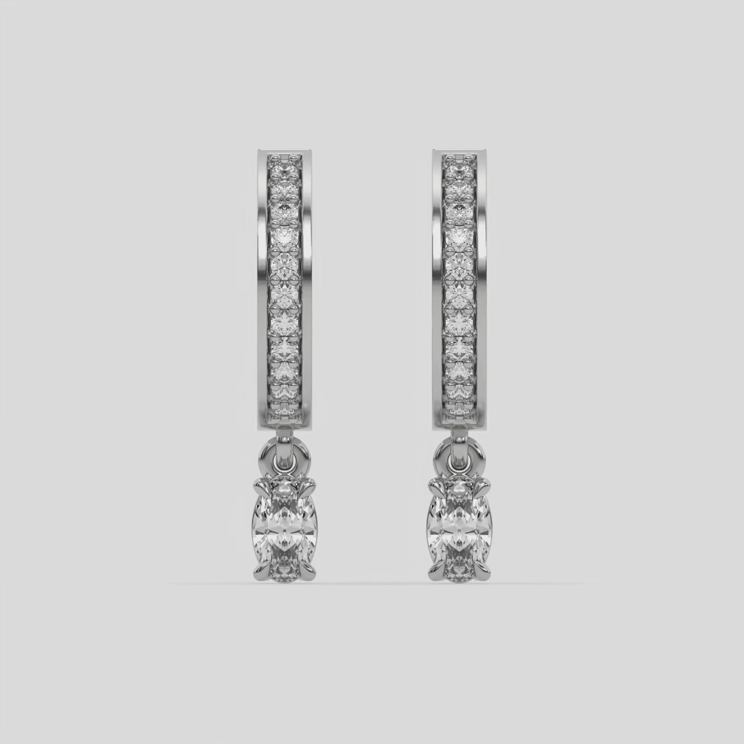 This video features a white gold Dangling Oval Diamond Hoop Earrings handmade with round brilliant-cut diamonds in pave setting and an oval solitaire hanging at the bottom