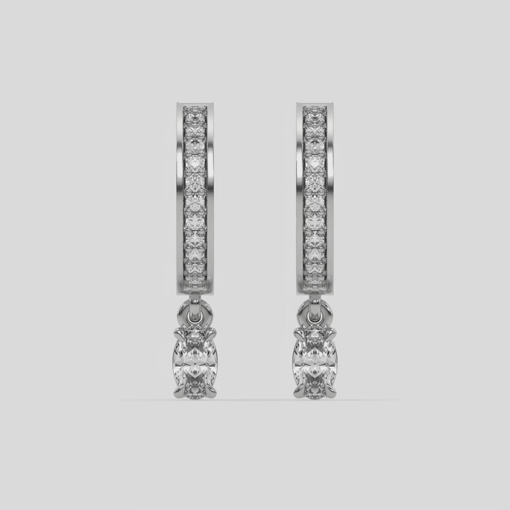 This video features a white gold Dangling Oval Diamond Hoop Earrings handmade with round brilliant-cut diamonds in pave setting and an oval solitaire hanging at the bottom