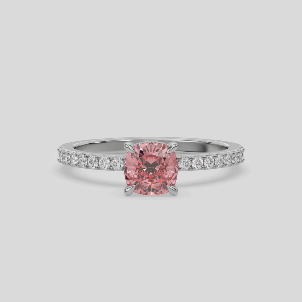 This video features a white gold ring is made with a fancy Pink cushion solitaire diamond set in four-prong setting