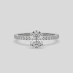 This video features a white gold ring is made with an oval solitaire diamond set in four-prong setting, and is complemented by a round pave diamonds band 