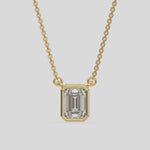 This yellow gold Emerald Solitaire Diamond Necklace made with an emerald cut diamond in bezel setting with adjustable chain 